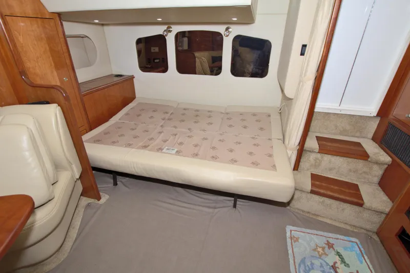 High Hopes Yacht Photos Pics Interior cabin of 2004 Cruisers Yachts 370 Express with convertible bed and wooden accents.