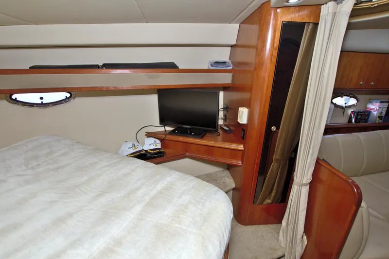 High Hopes Yacht Photos Pics 2004 Cruisers Yachts 370 Express cabin interior with bed, TV, and wooden furnishings.
