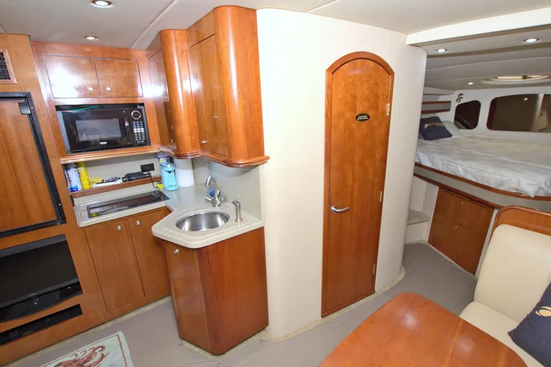 High Hopes Yacht Photos Pics 2004 Cruisers Yachts 370 Express interior with kitchenette, sink, and cozy sleeping area.