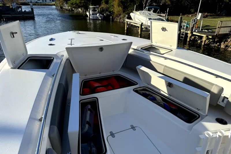  Yacht Photos Pics 2021 Cape Horn 32 XS boat with open storage compartments on a calm waterway.