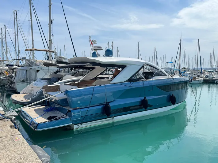 Mamina Yacht Photos Pics 2024 Jeanneau DB/43 IB yacht docked in a marina, surrounded by sailboats.