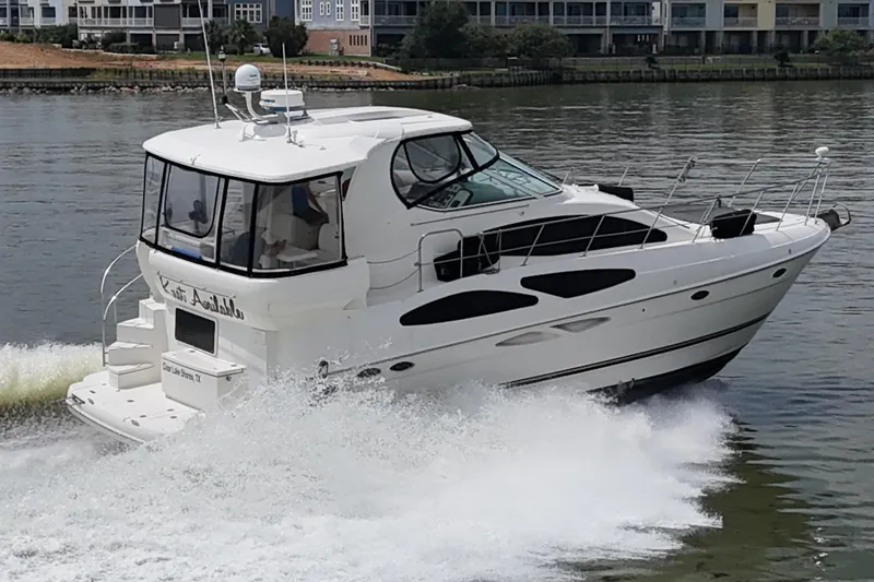 Knot Available Yacht Photos Pics 2004 Cruisers Yachts 405 Express Motoryacht cruising on a calm river near waterfront homes.