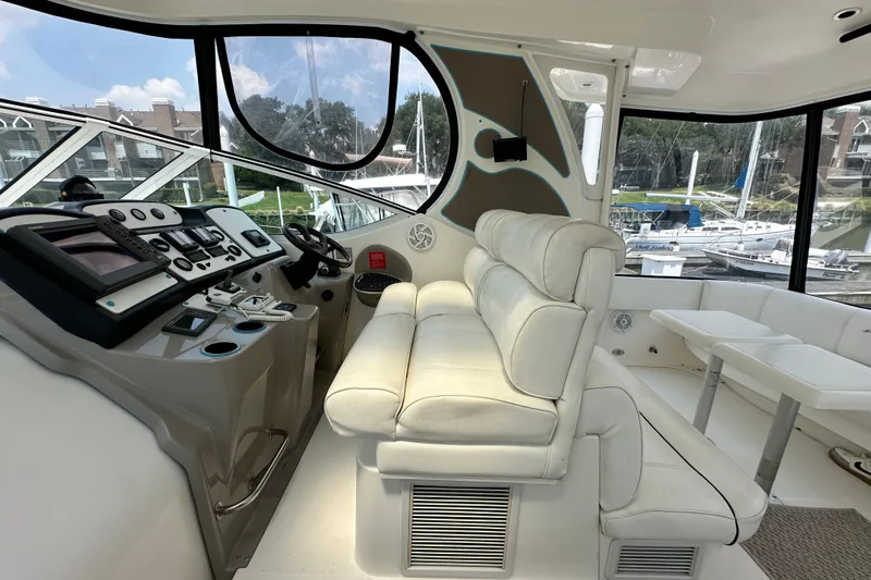 Knot Available Yacht Photos Pics 2004 Cruisers Yachts 405 Express Motoryacht helm with white leather seating and control panel.