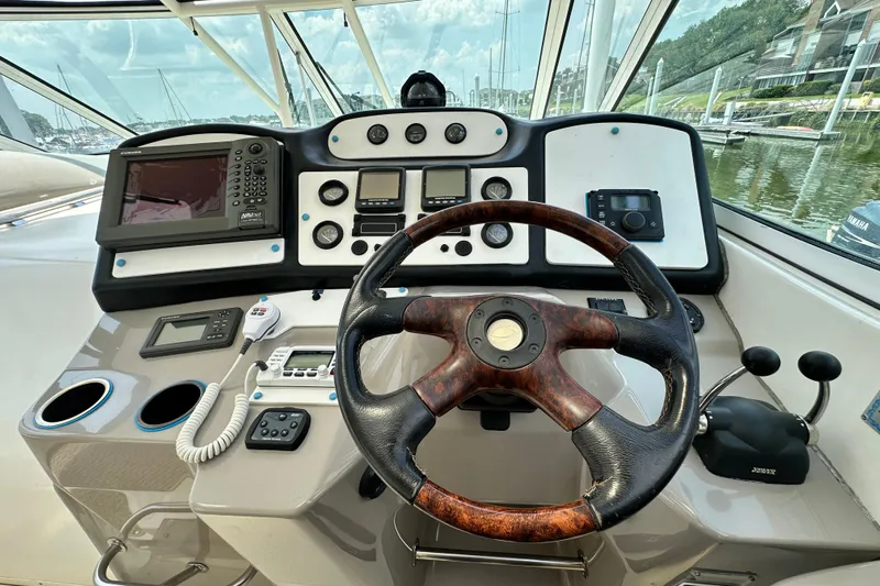 Knot Available Yacht Photos Pics 2004 Cruisers Yachts 405 Express Motoryacht helm with steering wheel and navigation controls.