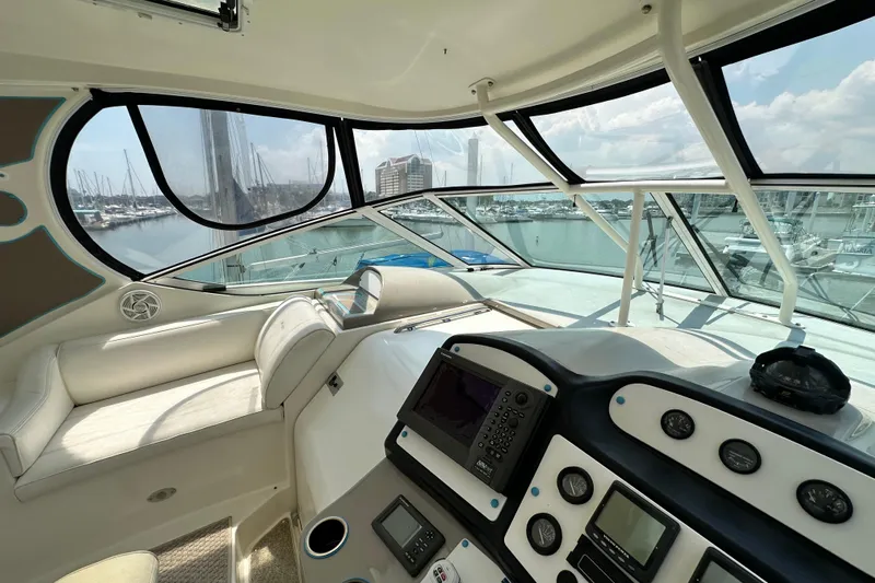 Knot Available Yacht Photos Pics 2004 Cruisers Yachts 405 Express Motoryacht helm with marina view, featuring navigation instruments.