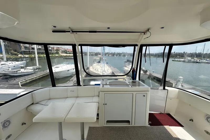 Knot Available Yacht Photos Pics Interior view of 2004 Cruisers Yachts 405 Express Motoryacht, featuring seating and marina backdrop.