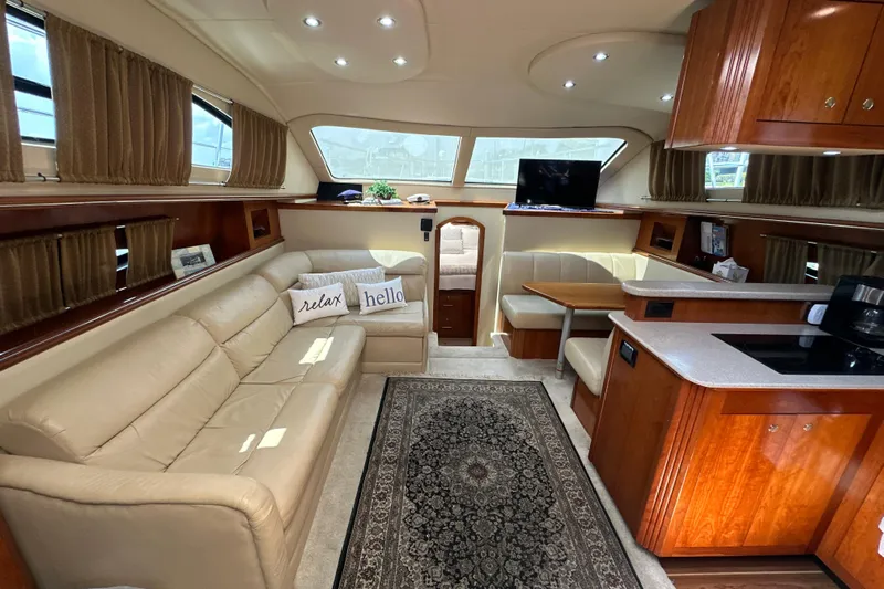 Knot Available Yacht Photos Pics Luxurious interior of 2004 Cruisers Yachts 405 Express Motoryacht with leather seating and wood cabinetry.