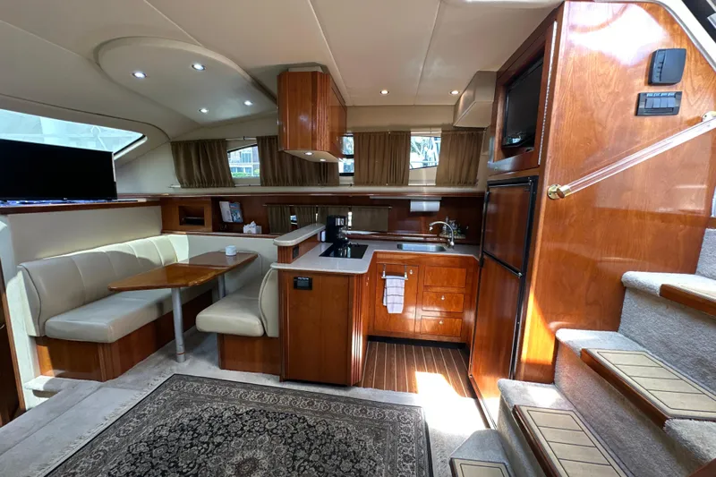 Knot Available Yacht Photos Pics Luxurious interior of 2004 Cruisers Yachts 405 Express Motoryacht with kitchen and dining area.