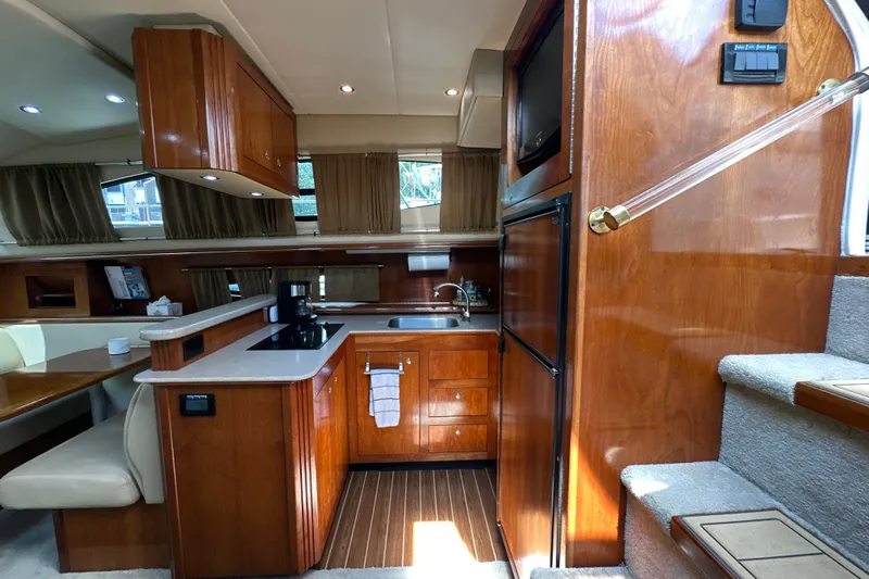 Knot Available Yacht Photos Pics 2004 Cruisers Yachts 405 Express Motoryacht interior with wooden cabinetry and modern kitchen amenities.