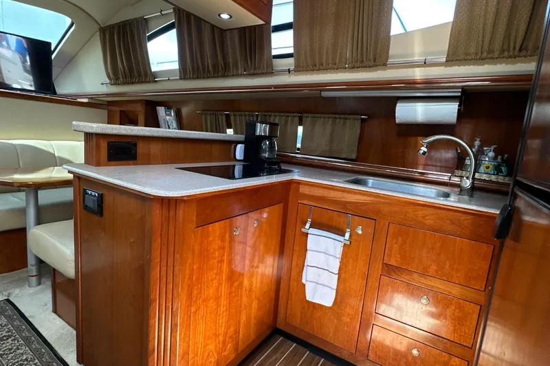 Knot Available Yacht Photos Pics Luxurious 2004 Cruisers Yachts 405 Express Motoryacht kitchen with wood cabinetry and modern amenities.