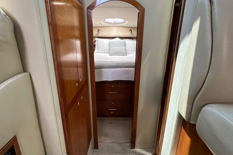 Knot Available Yacht Photos Pics 2004 Cruisers Yachts 405 Express Motoryacht interior with cozy bedroom and wooden cabinetry.
