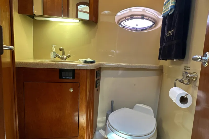 Knot Available Yacht Photos Pics 2004 Cruisers Yachts 405 Express Motoryacht bathroom with sink, toilet, and porthole window.