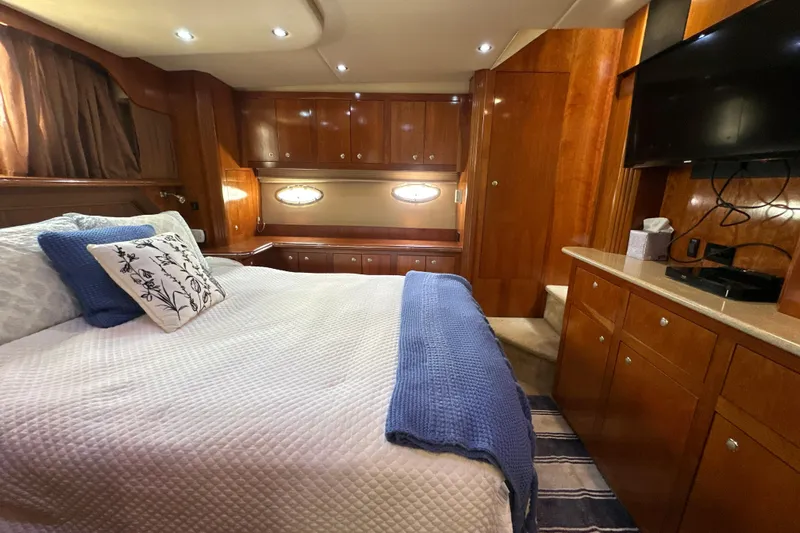 Knot Available Yacht Photos Pics Luxurious 2004 Cruisers Yachts 405 Express Motoryacht bedroom with elegant wood cabinetry.