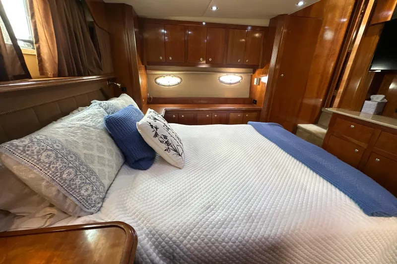 Knot Available Yacht Photos Pics Luxurious bedroom interior of 2004 Cruisers Yachts 405 Express Motoryacht with elegant wood finish.