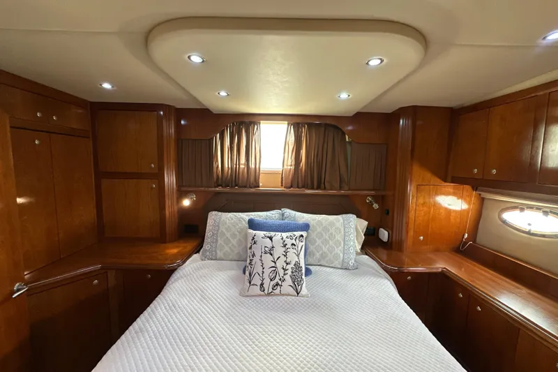 Knot Available Yacht Photos Pics Luxurious 2004 Cruisers Yachts 405 Express Motoryacht bedroom with elegant wood cabinetry.