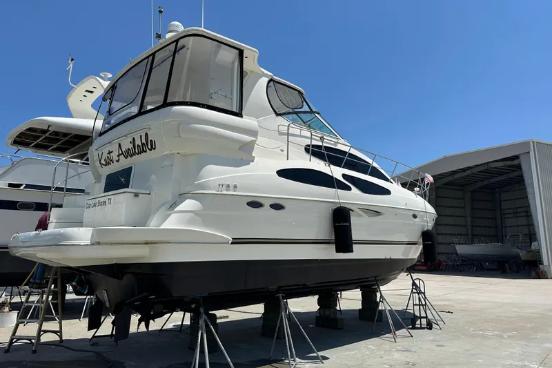 Knot Available Yacht Photos Pics 2004 Cruisers Yachts 405 Express Motoryacht on stands, in a marina setting.