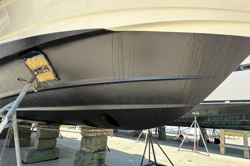 Knot Available Yacht Photos Pics 2004 Cruisers Yachts 405 Express Motoryacht hull on dry dock, supported by blocks.