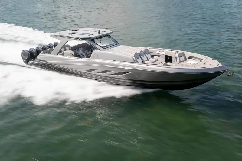  Yacht Photos Pics 2026 Deep Impact 499 Sport boat speeding on water, showcasing sleek design and powerful engines.
