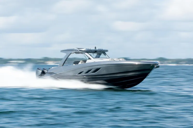  Yacht Photos Pics 2026 Deep Impact 499 Sport boat speeding on open water, showcasing sleek design and performance.