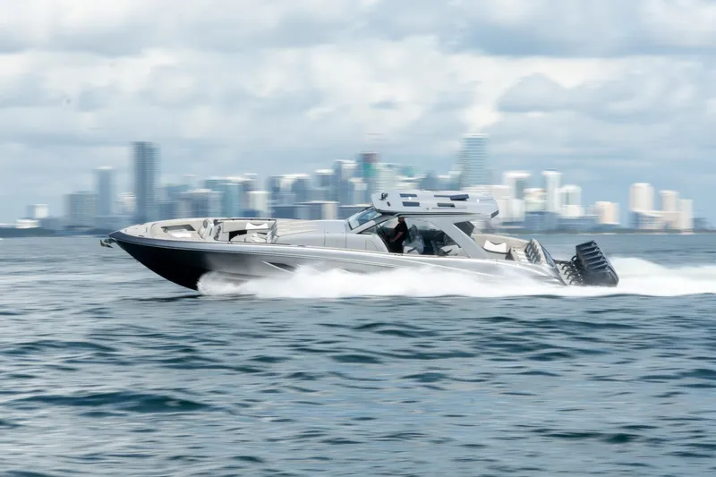  Yacht Photos Pics 2026 Deep Impact 499 Sport boat speeding on water with city skyline in background.