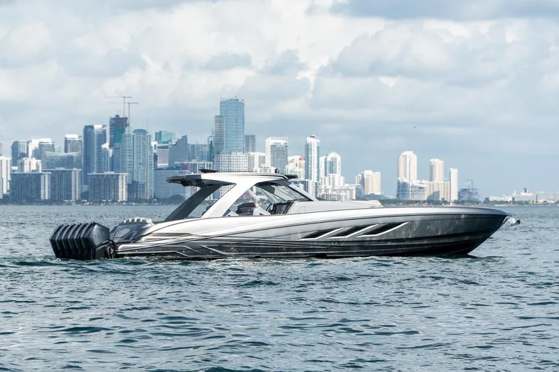  Yacht Photos Pics 2026 Deep Impact 499 Sport boat cruising near city skyline.