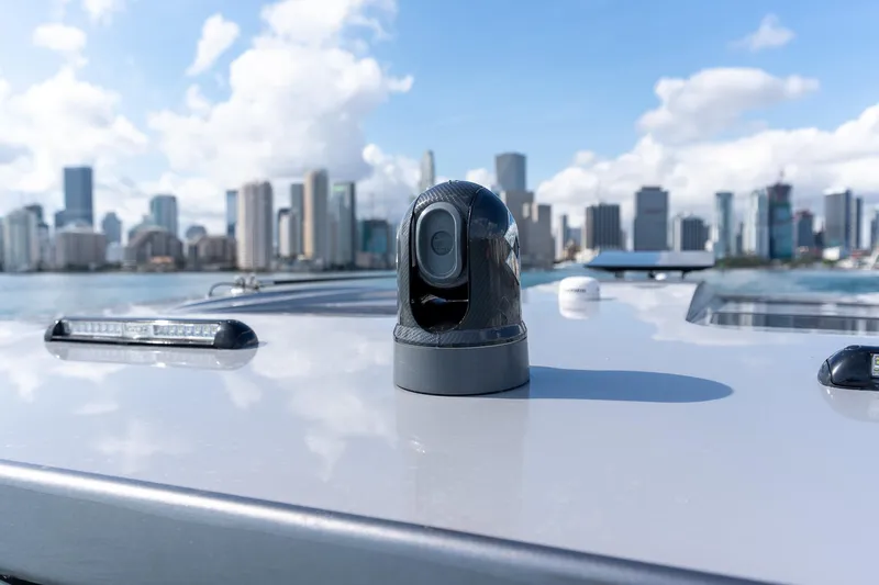  Yacht Photos Pics 2026 Deep Impact 499 Sport boat with city skyline in background, featuring advanced camera system.