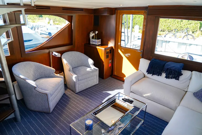 Soteria Yacht Photos Pics Luxurious interior of 1999 Hatteras 70 Convertible yacht with elegant seating and modern decor.