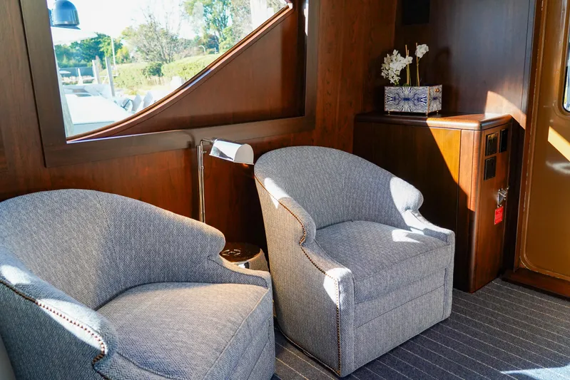 Soteria Yacht Photos Pics Interior of 1999 Hatteras 70 Convertible yacht with elegant seating and wooden accents.