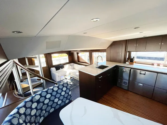 Soteria Yacht Photos Pics Interior of 1999 Hatteras 70 Convertible yacht with modern kitchen and seating area.