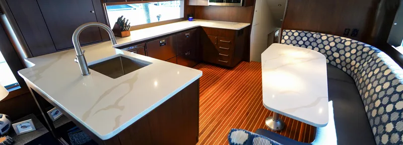 Soteria Yacht Photos Pics Luxurious interior of a 1999 Hatteras 70 Convertible yacht with modern kitchen and seating area.