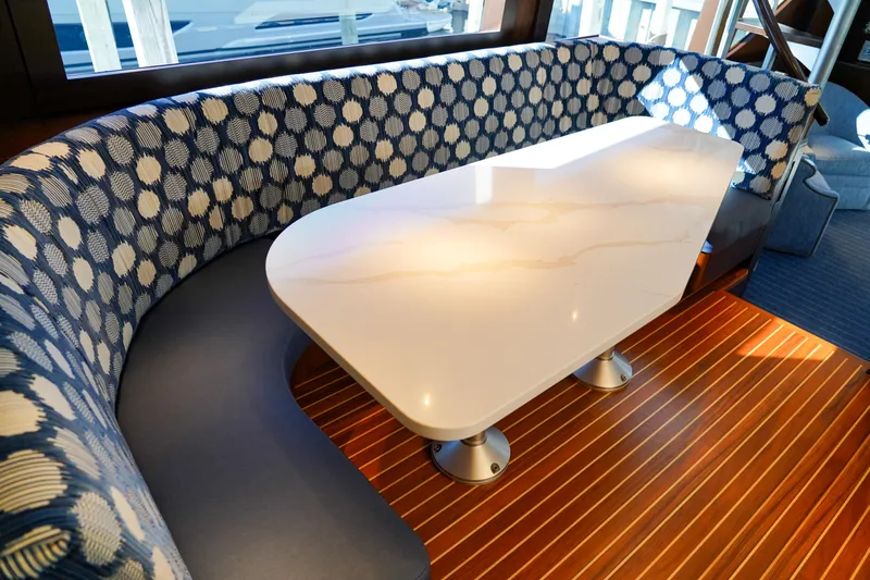 Soteria Yacht Photos Pics Luxurious dining area on 1999 Hatteras 70 Convertible yacht with elegant seating and table.