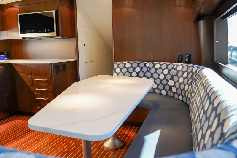 Soteria Yacht Photos Pics Luxurious interior of 1999 Hatteras 70 Convertible yacht with elegant dining area and modern amenities.