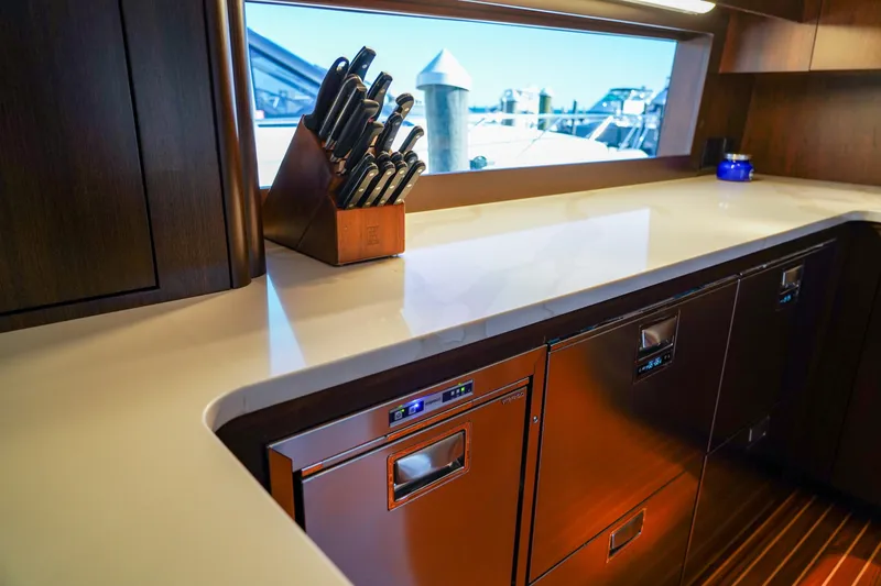 Soteria Yacht Photos Pics Luxurious kitchen interior of 1999 Hatteras 70 Convertible yacht with modern appliances and knife set.