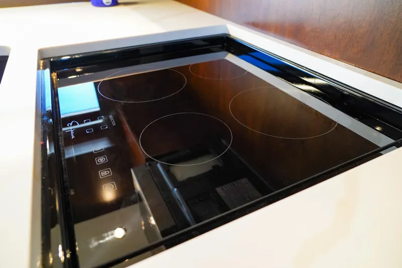 Soteria Yacht Photos Pics Modern electric cooktop on 1999 Hatteras 70 Convertible yacht kitchen.