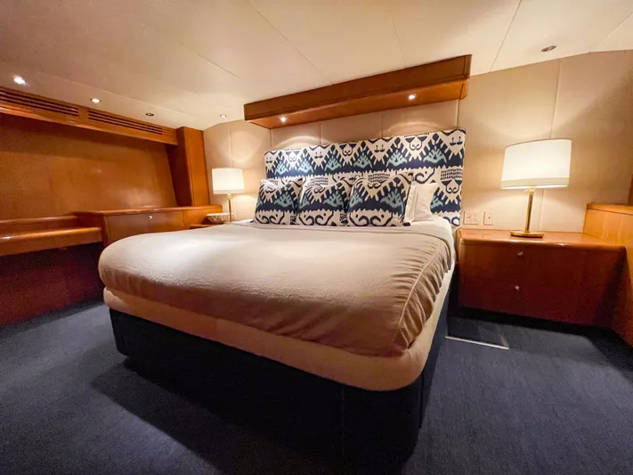 Soteria Yacht Photos Pics Luxurious bedroom interior of 1999 Hatteras 70 Convertible yacht with elegant bedding and lighting.