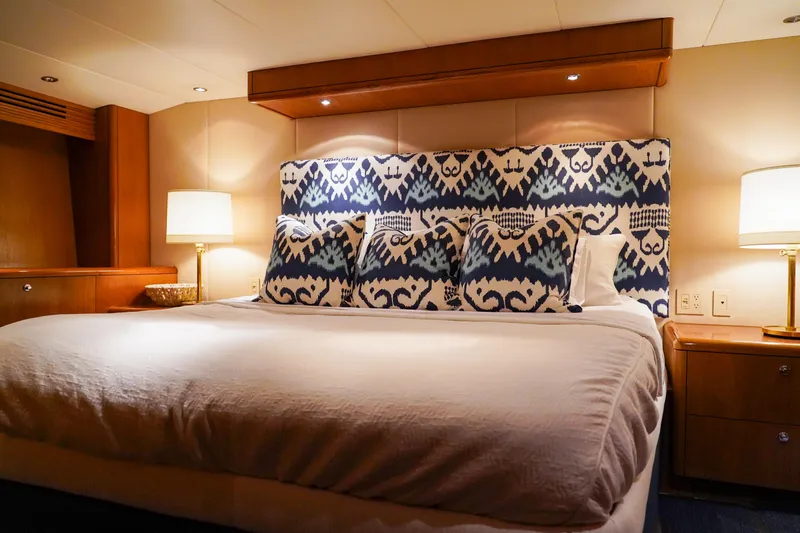 Soteria Yacht Photos Pics Luxurious bedroom interior on 1999 Hatteras 70 Convertible yacht with elegant decor and lighting.