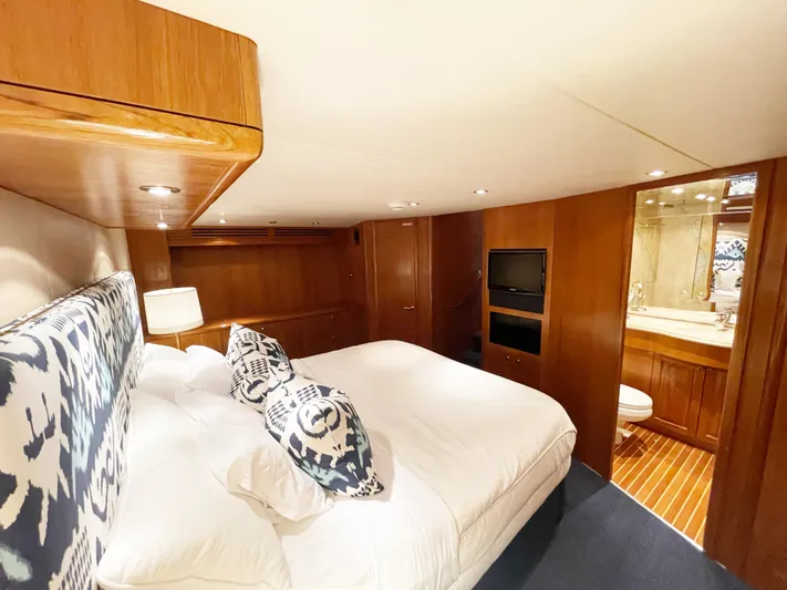 Soteria Yacht Photos Pics Luxurious bedroom interior of 1999 Hatteras 70 Convertible yacht with ensuite bathroom.