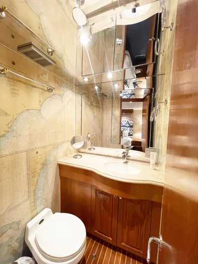 Soteria Yacht Photos Pics Luxurious bathroom in 1999 Hatteras 70 Convertible yacht with nautical decor and wooden cabinetry.