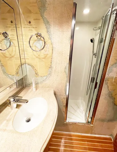 Soteria Yacht Photos Pics Luxurious bathroom in 1999 Hatteras 70 Convertible yacht with nautical map decor.