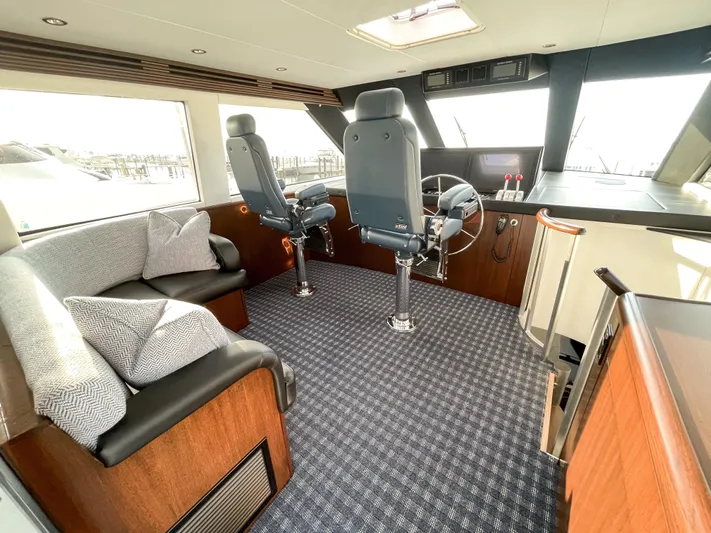 Soteria Yacht Photos Pics Luxurious interior of 1999 Hatteras 70 Convertible yacht with helm and seating area.