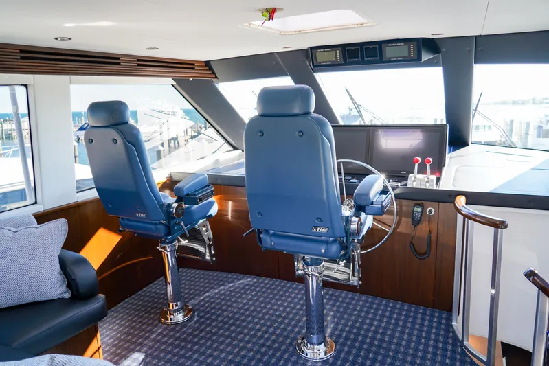 Soteria Yacht Photos Pics Interior helm of 1999 Hatteras 70 Convertible yacht with blue captain chairs.
