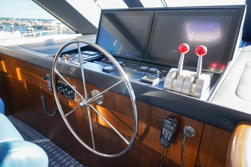 Soteria Yacht Photos Pics Helm of 1999 Hatteras 70 Convertible yacht with steering wheel and control panel.