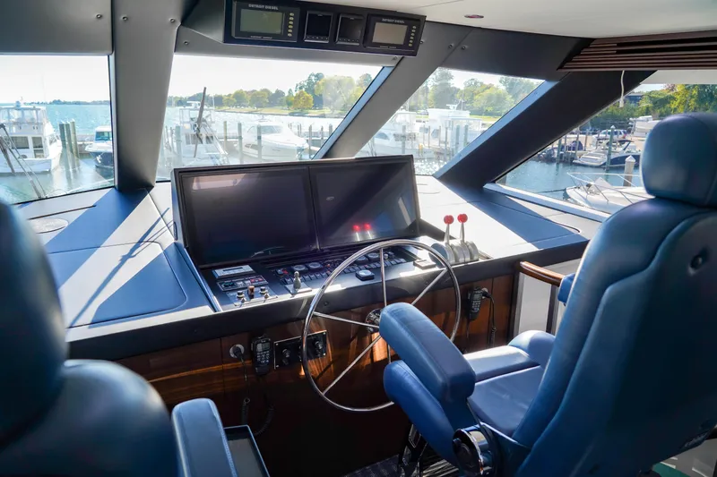 Soteria Yacht Photos Pics Helm of 1999 Hatteras 70 Convertible yacht with dual screens and blue captain's chair.