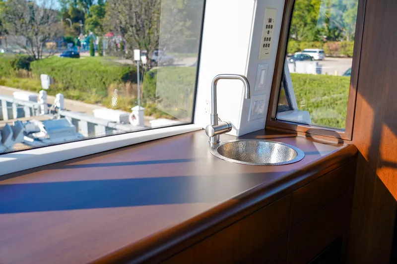 Soteria Yacht Photos Pics Interior view of 1999 Hatteras 70 Convertible yacht with sleek sink and window.