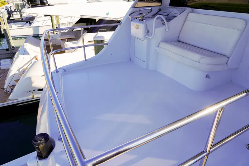 Soteria Yacht Photos Pics 1999 Hatteras 70 Convertible yacht deck with seating and steering wheel.