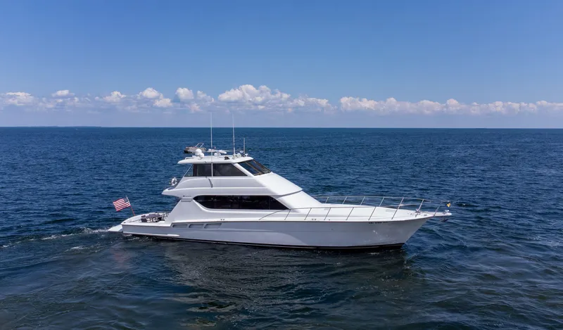 Soteria Yacht Photos Pics 1999 Hatteras 70 Convertible yacht cruising on open sea under clear blue sky.