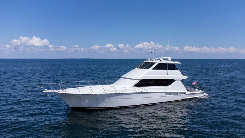 Soteria Yacht Photos Pics 1999 Hatteras 70 Convertible yacht cruising on open sea under clear blue sky.