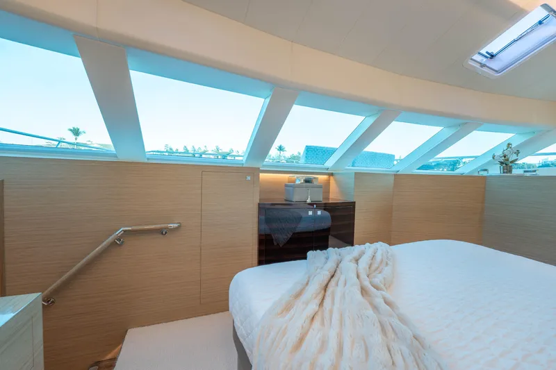 Homarus Yacht Photos Pics Luxurious yacht bedroom with large windows, modern decor, and cozy bedding, Horizon 2021 model.