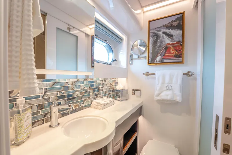 Homarus Yacht Photos Pics Luxurious yacht bathroom with modern fixtures, ocean-themed decor, and framed boat photo.