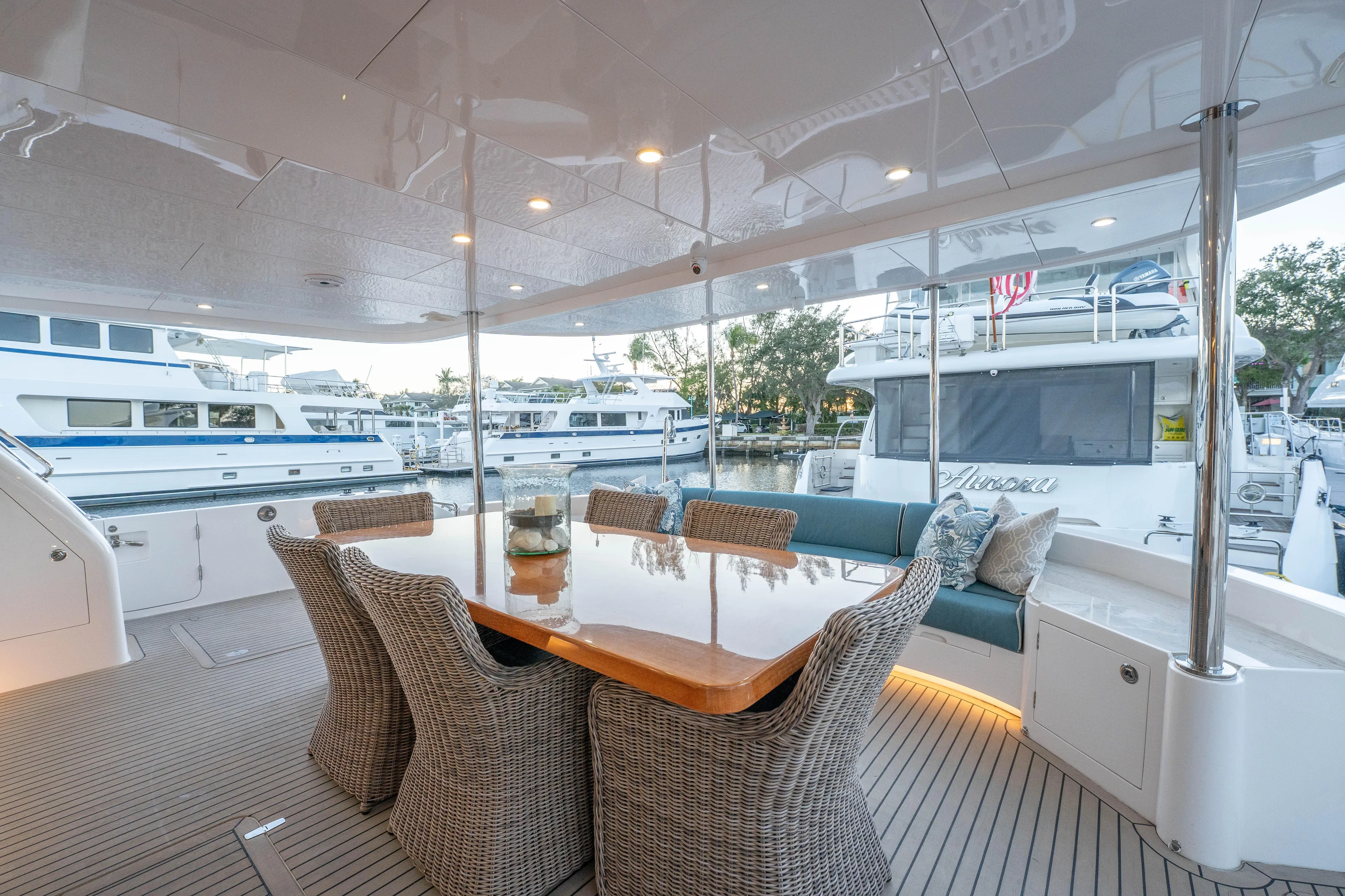 Homarus Yacht Photos Pics Luxurious Horizon yacht deck with dining area, wicker chairs, and marina view, 2021 model.